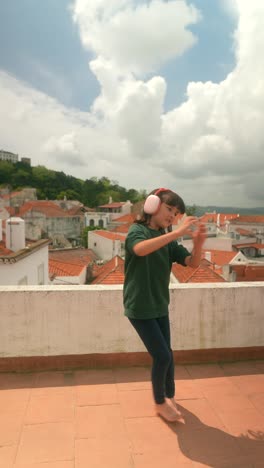 girl dancing on rooftop with headphones