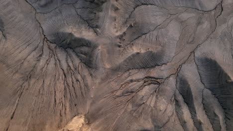 aerial top down over huge brown stone mountain peak with no sign of life