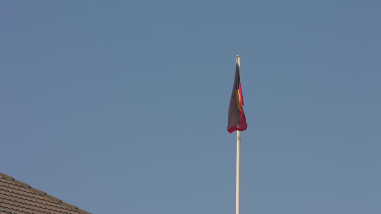 la bandera aborigen se encuentra en alto sobre el pabellón bondi en la playa de sídney, australia.