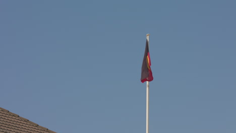 La-Bandera-Aborigen-Se-Alza-Sobre-El-Pabellón-Bondi-En-La-Playa-De-Sydney,-Australia.