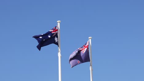 two australian flags fluttering against a clear sky