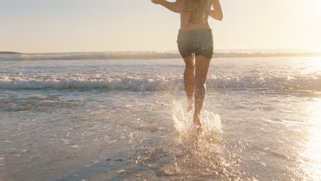 girl friends running on beach into sea having fun splashing in water teenage girls enjoying warm summer day on vacation