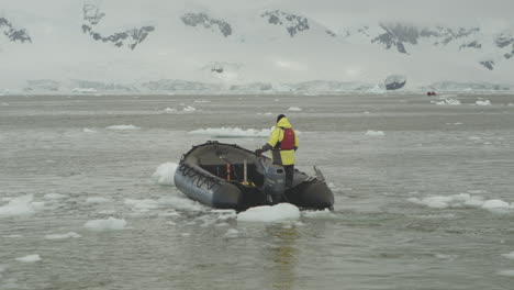 a zodiac maneuverers between small ice bergs in antarctica