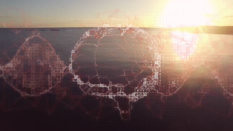 animación de un cerebro digital girando sobre el mar y el cielo al atardecer