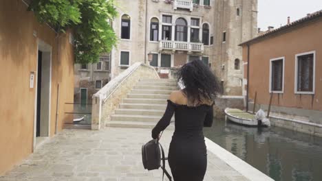 curly girl walking and spinning on a bridge in venice slow motion