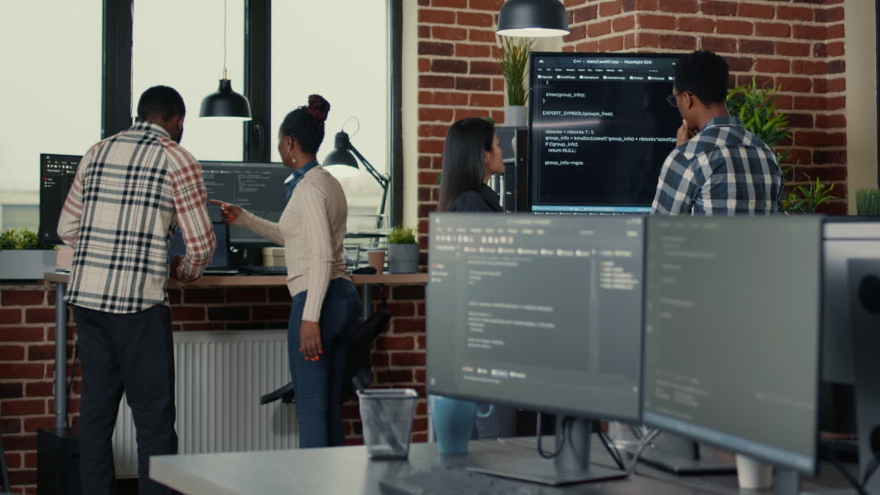 System developers analyzing code on wall screen tv looking for errors