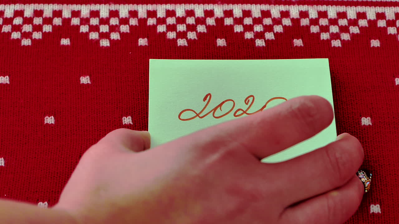 빨간색 디자인 배경에 대해 연도의 변화를 보여주는 또 다른 포스트잇 노트의 손 이동 스택