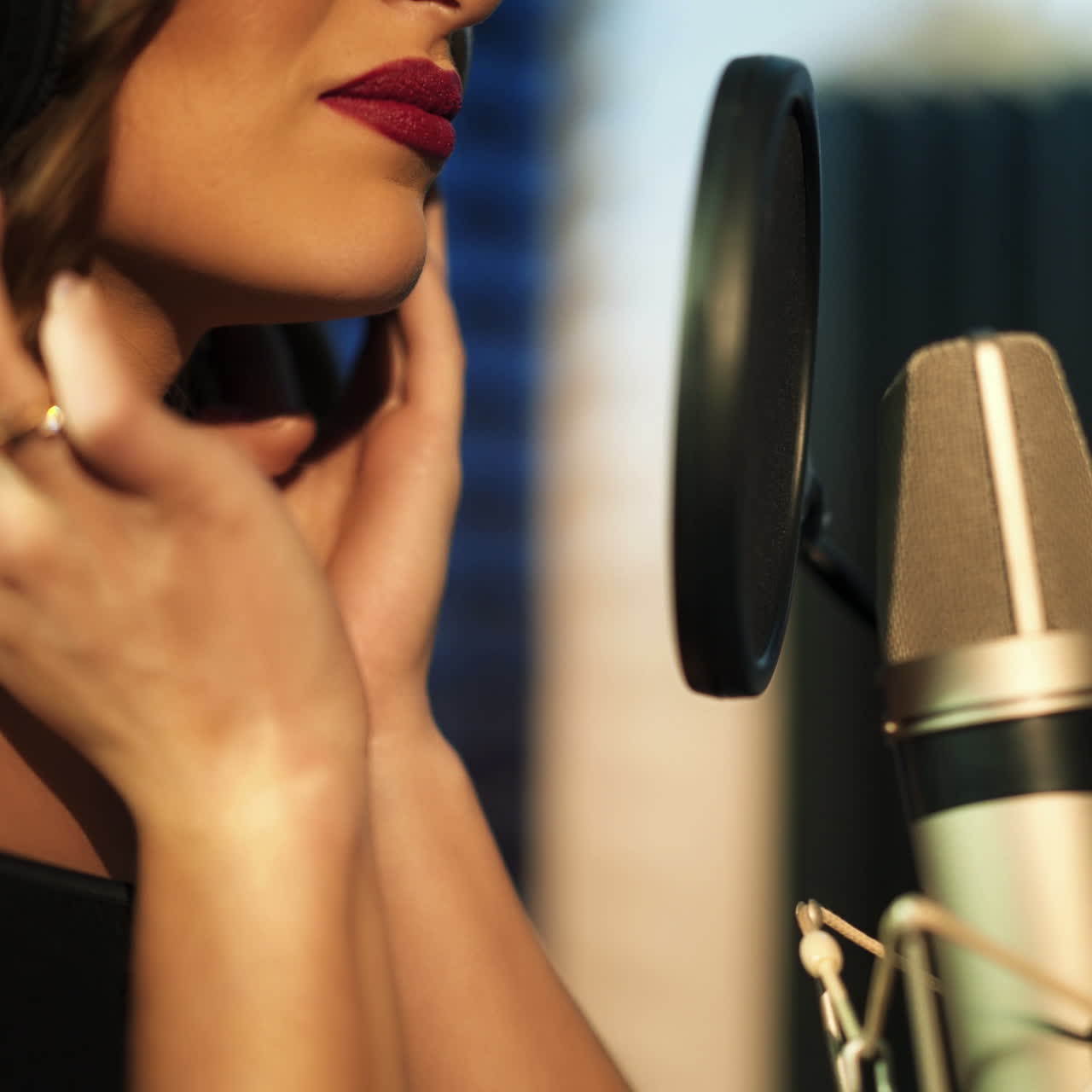 Beautiful woman in headphones records a song in a professional recording studio. Face close-up Square video