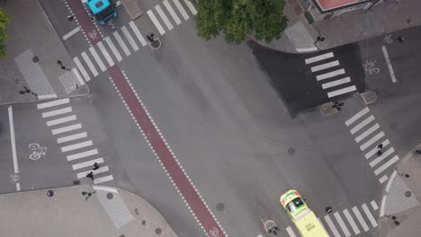 Top-down-view-of-scandinavian-roads,-crosswalks-and-cars-driving-on-Uggleviksvägen-and-Karlavägen-on-Östermalm-in-Stockholm,-Sweden