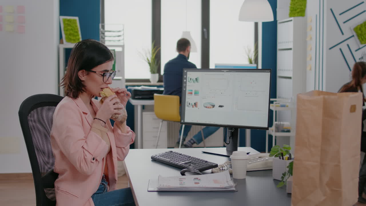 mujer de negocios comiendo un sabroso sándwich teniendo una pausa para comer trabajando en una empresa de negocios