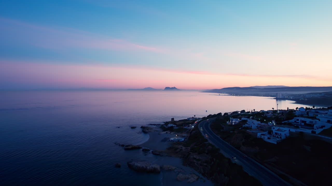 Aerial view of the coast of Spain after sundown, with rock of Gibraltar and the cosat of Morocco on the background