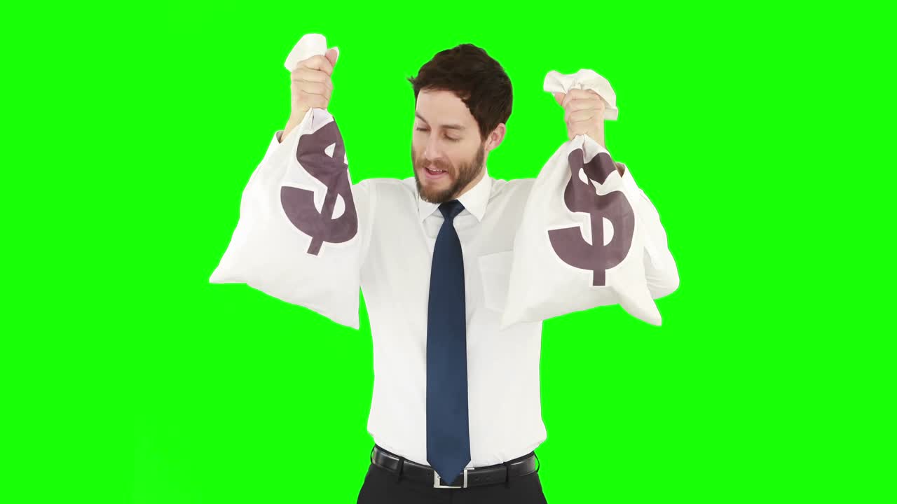 Happy businessman showing bags of money