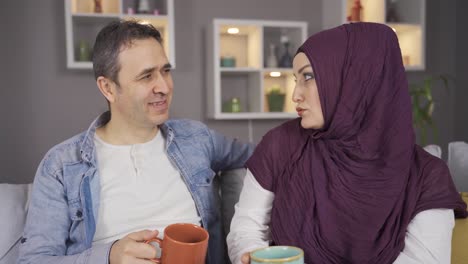 happy muslim couple having intimate conversation at their home.