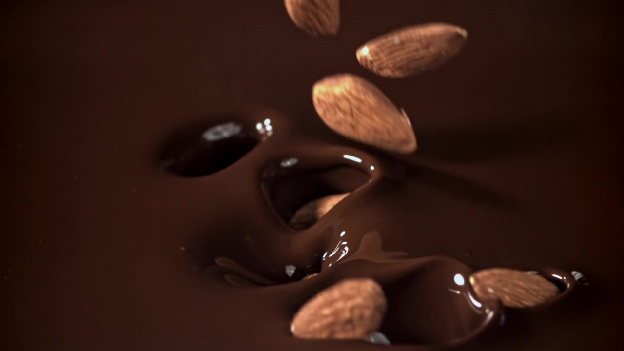 Almond Lezat Jatuh dan Memercik ke dalam Cokelat Leleh Pekat