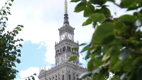 Revealing-Shot-Of-Clock-Tower-And-Antenna-Spire-Of-The-Palace-Of-Culture-And-Science-In-Warsaw,-Poland