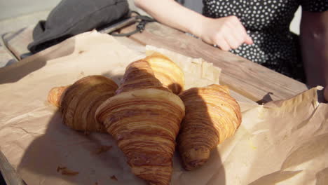 fresh tasty croissants laying on a table outside a cafe on a sunny day