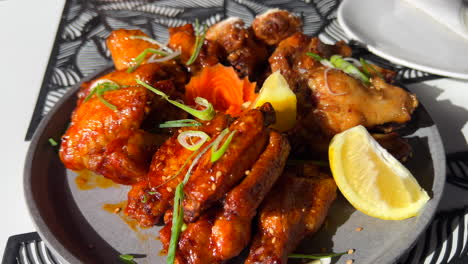 Hot-and-spicy-chicken-wings-in-sticky-bbq-sauce-with-spring-onion-and-lemon-slices,-Asian-cuisine,-4K-shot