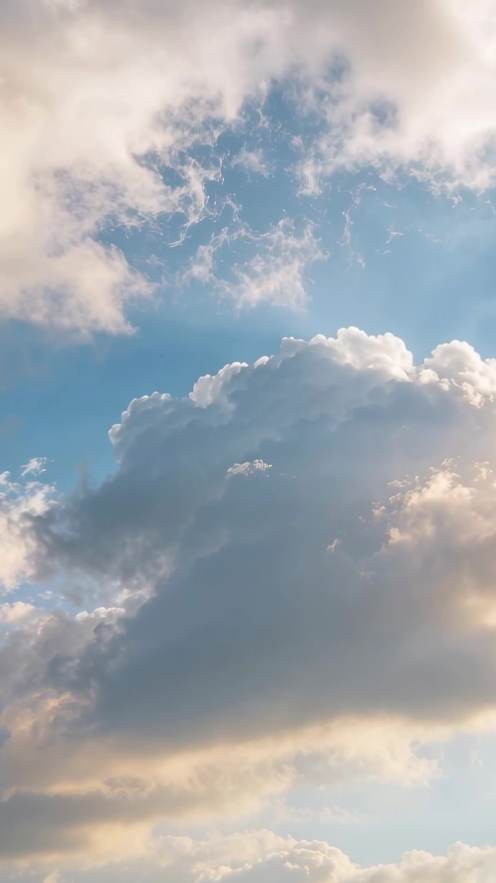Video verticale: Grande nuvola che si sposta a destra con la brezza, il sole che colpisce la base generando raggi caldi per il design.