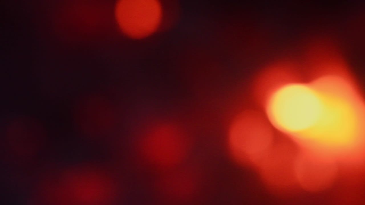 As brasas de uma fogueira estão desfocadas. Fundo bokeh em tons de laranja