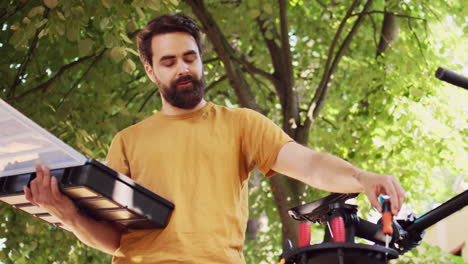 young man organizing bicycle work tools