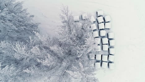 top down aerial view of hay bales on a farmers field covered in snow