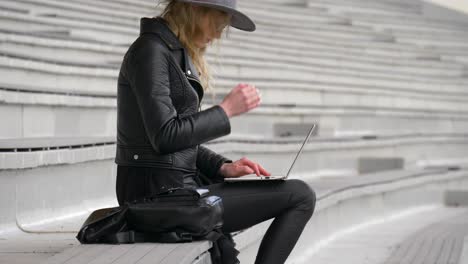 moving up view shot of confident business woman working outside with her laptop