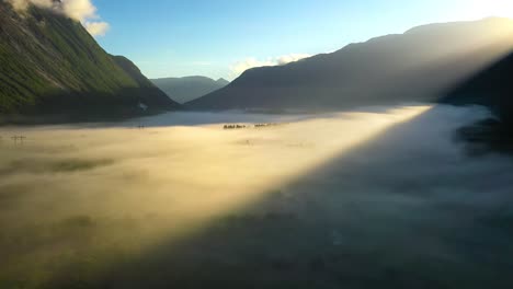 morning mist over the valley among the mountains in the sunlight. fog and beautiful nature of norway aerial footage.