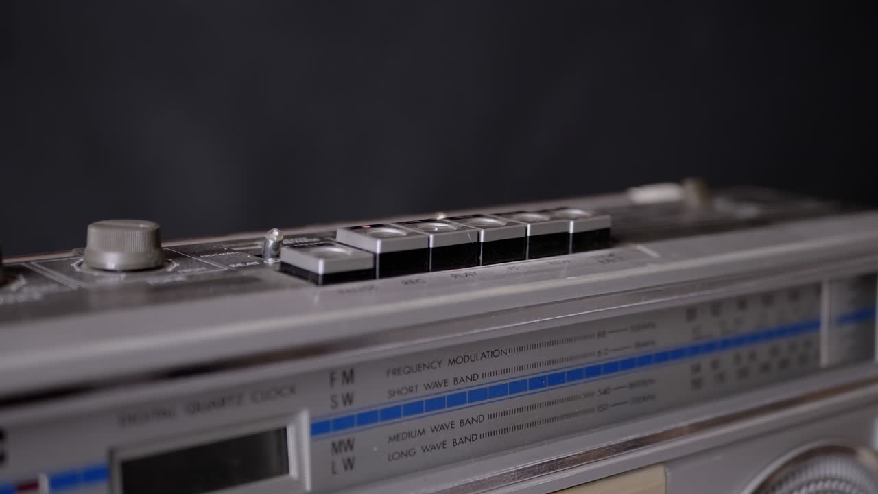 어두운 방에서 오래된 빈티지 테이프 레코더의 버튼을 누르는 여성 손가락