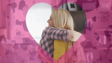 animación de formas de corazón sobre una madre caucásica feliz y una hija adulta abrazándose en casa