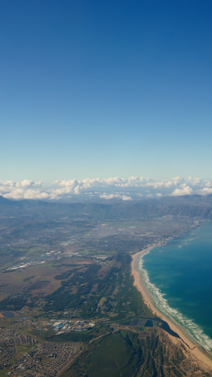 Aerial view of a coastal city with mountains and beach