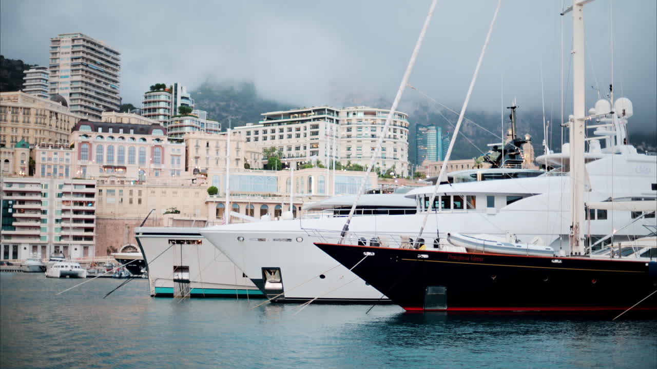 Vista delle barche ormeggiate nel porto turistico di Monaco con lo skyline della città sullo sfondo
