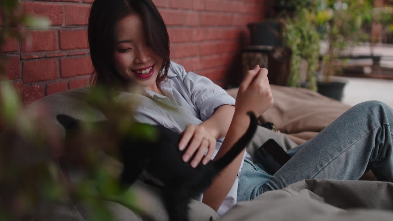 Woman with cat near brick wall