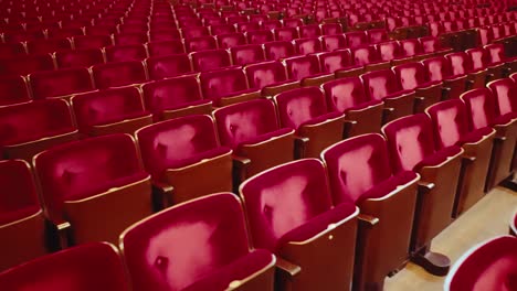 rows of empty red velvet seats at unsold and closed event dolly to left