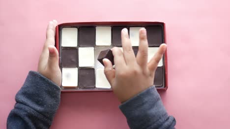 hands holding a box of assorted chocolates