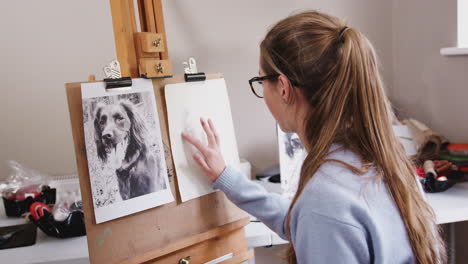 Weibliche-Teenager-Künstlerin-Sitzt-An-Der-Staffelei-Und-Zeichnet-Mit-Kohle-Ein-Bild-Eines-Hundes-Aus-Einem-Foto