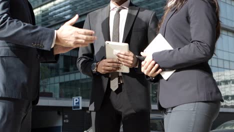 cropped short of coworkers shaking hands on street