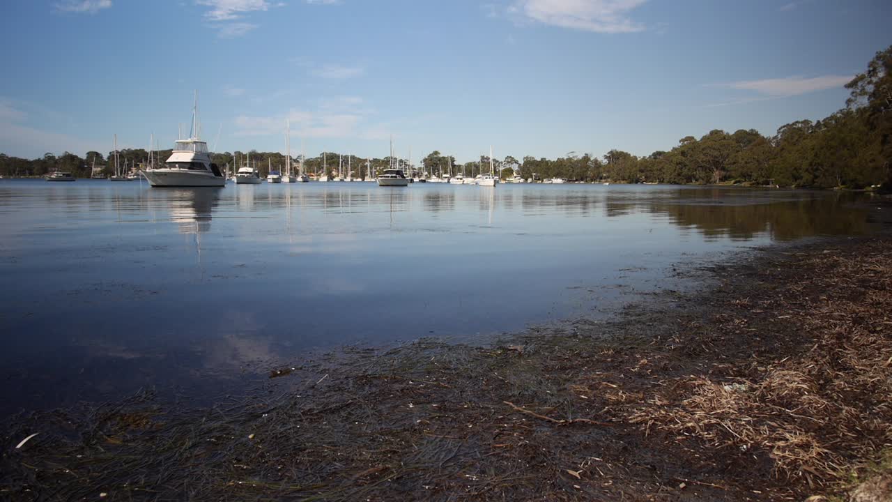 Waterside, boats moored on a clam relaxing morning, wide shot