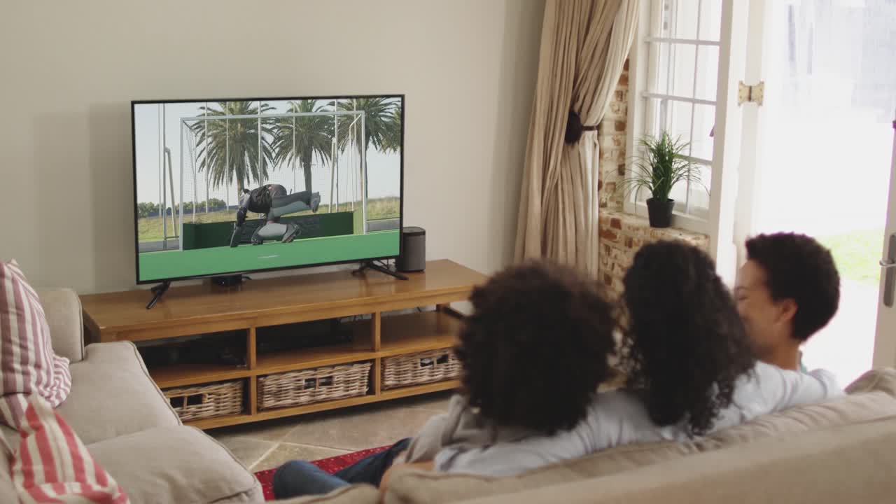 Famiglia felice seduta a casa insieme che guarda una partita di hockey in TV