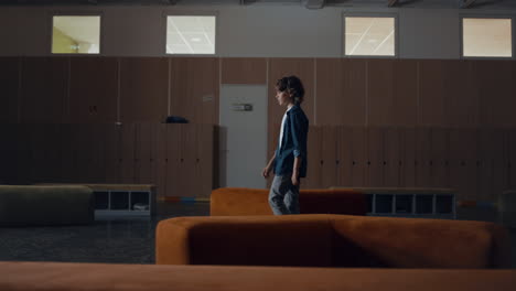 pupil boy walking empty hallway alone. bored teen schoolboy skipping classes.