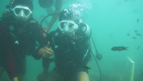 un chico disfrutando de la experiencia de buceo bajo el agua en un mar azul profundo