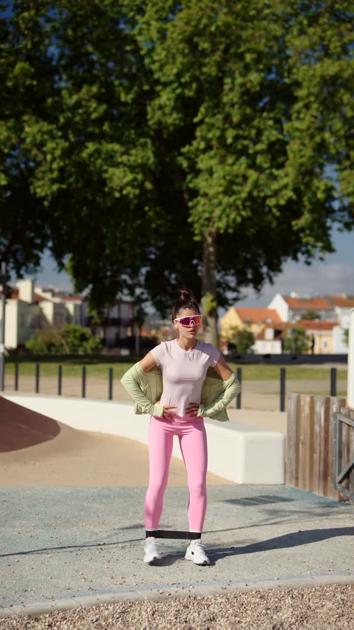 mujer haciendo ejercicio con banda de resistencia en un parque