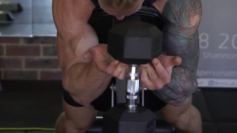 Muscly-man-in-home-gym-exercising-goblet-bicep-curl-dumbbell