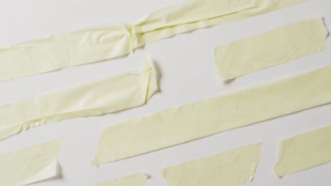 video de un primer plano de varias piezas rasgadas de papel amarillo con espacio de copia en un fondo blanco