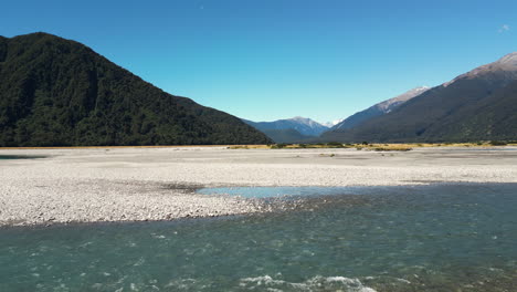 una toma de drones del río haast y las montañas en nueva zelanda