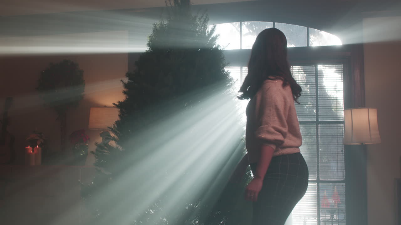 Woman with Christmas Tree in Sunlit Room