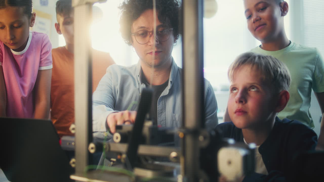 Teacher demonstrating 3D printing to students in a classroom.