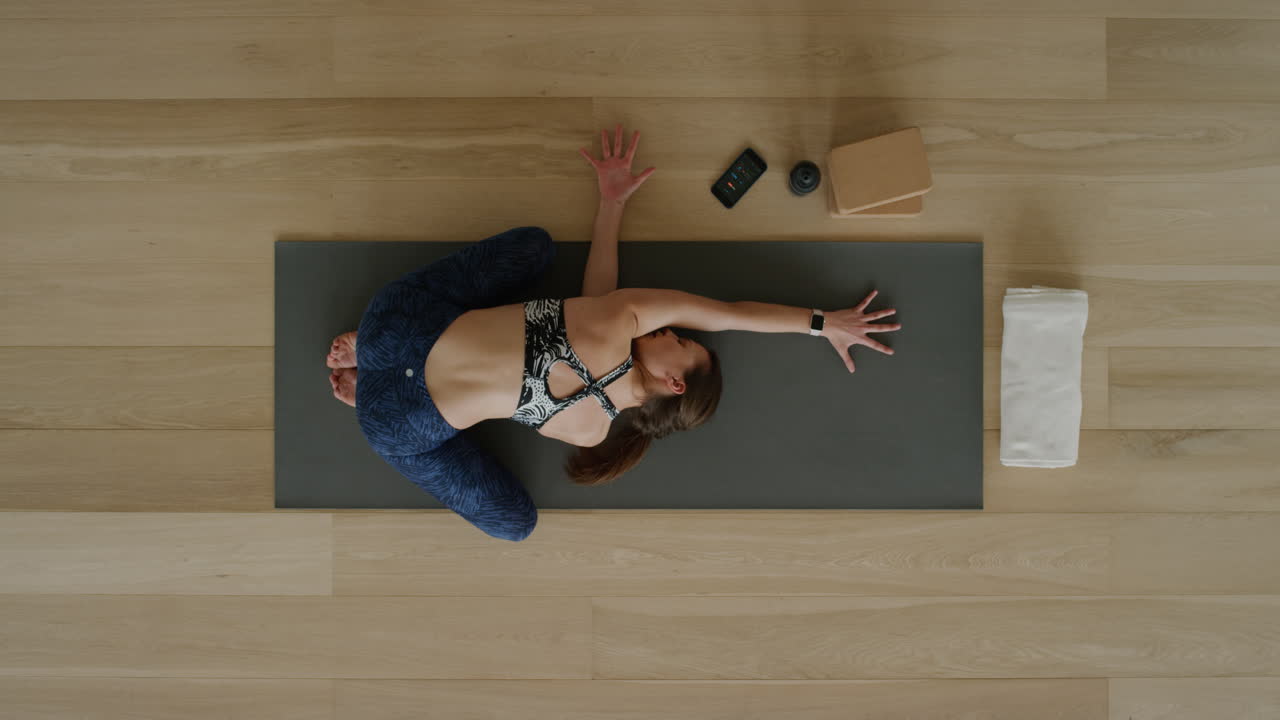 vista superior de una mujer de yoga practicando posturas en un estudio de entrenamiento disfrutando de un estilo de vida saludable practicando meditación en una colchoneta de ejercicios