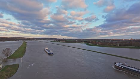 siguiente disparo de avión no tripulado mientras los buques de carga se pasan el uno al otro en el río rijn durante los niveles altos de agua