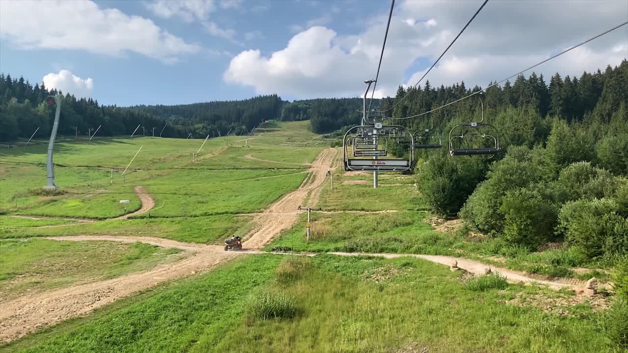 Una funivia vuota in una soleggiata giornata estiva con vista sulla montagna.