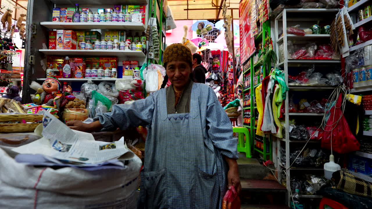 Aymara woman selling traditional ritual items such as amulets, herbal remedies, and symbolic charms at the atmospheric Witches’ Market (Mercado de las Brujas) in La Paz, Bolivia